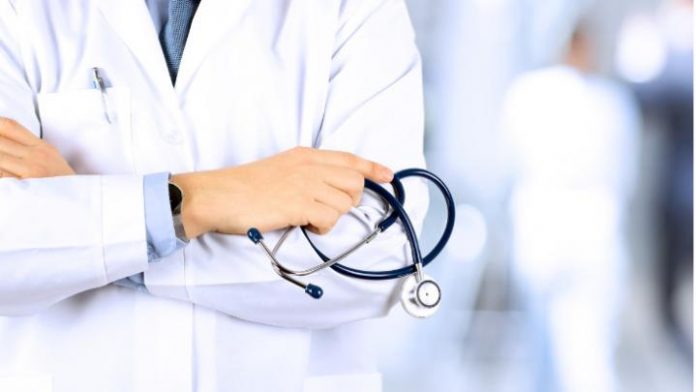 portrait-an-unknown-male-doctor-holding-a-stethoscope-behind-picture-id517051420