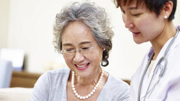 senior asian woman and family doctor having a discussing using tablet computer
