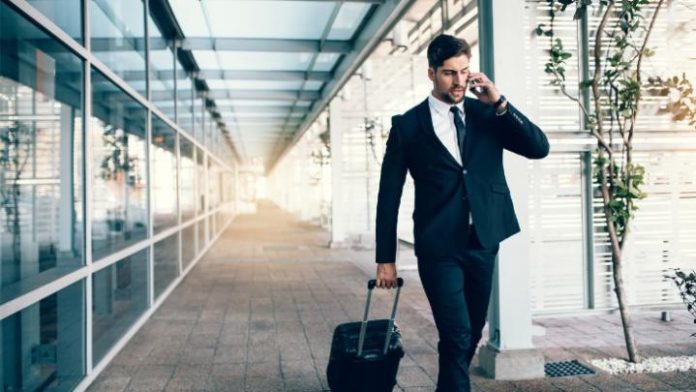 travelling-businessman-making-phone-call-picture-id807418518