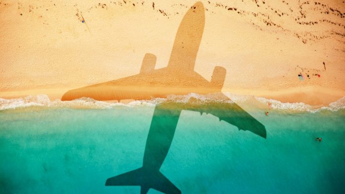 An airplane's shadow casted over a beach