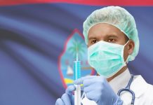 U.S. territory launches vaccine tourism programme Doctor holding a syringe in front of Guam flag
