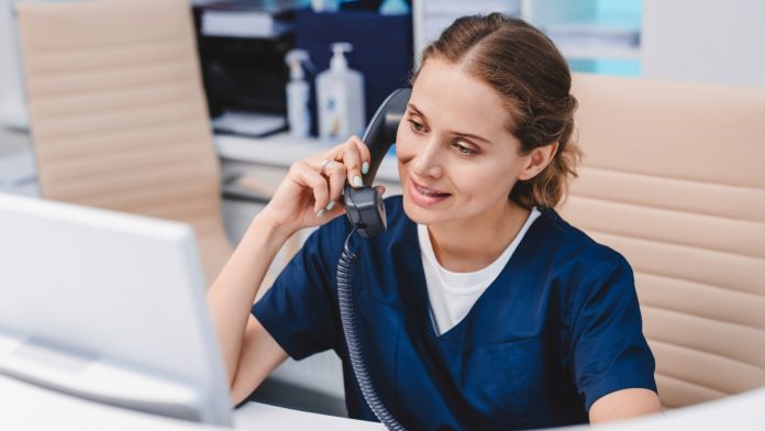 Receptionist_on_the_telephone_iStock-1275072681 Young receptionist talking on the telephone