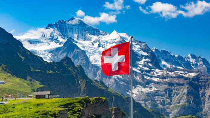 Swiss flag in front on mountains