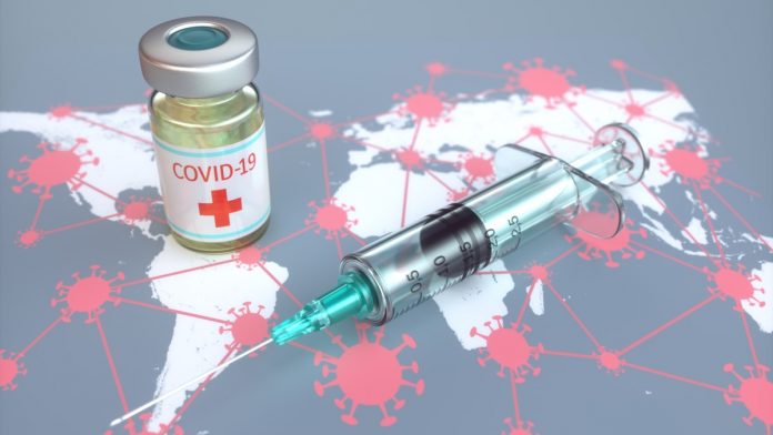A conceptual image of the COVID-19 vaccine sitting on a map of the world.