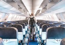 USA: not open yet for inbound travel A lonely passenger walking down an empty airplane aisle.