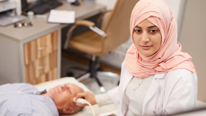 Young Arab woman performing a ultrasound scan on patient