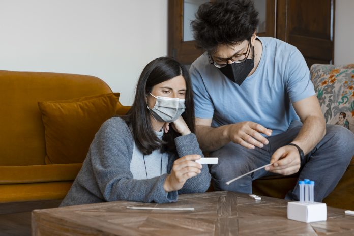 Man and woman checking the results of the Antigen Home Test for Coronavirus diagnostic.