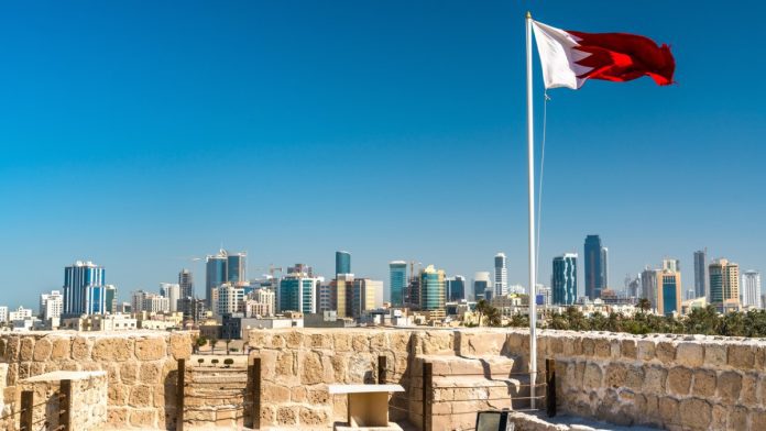 Bahrain flag and Manama skyline_iStock-925235464