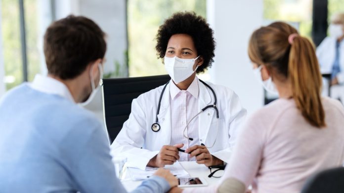 doctor talking to couple fertility treatment_iStock-1270585289 specialist treatment