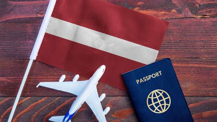 Latvia flag, toy plane and passport, which relates to medical tourism