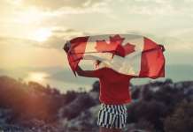 Canada domestic travel policies lack compassion Girl waving Canadian flag, referencing Canada domestic travel