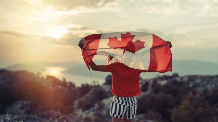 Girl waving Canadian flag, referencing Canada domestic travel