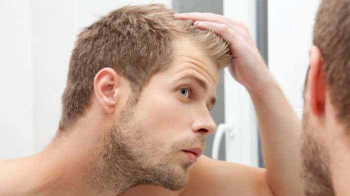 Man looking at hair loss, referencing hair transplant sector