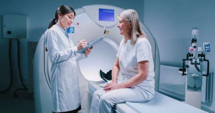 Remote,Shooting.,Female,Doctor,Is,Standing,Near,Patient,And,Explaining