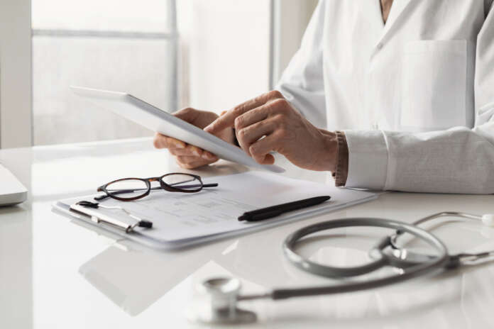 Doctor medical professional working on digital tablet
