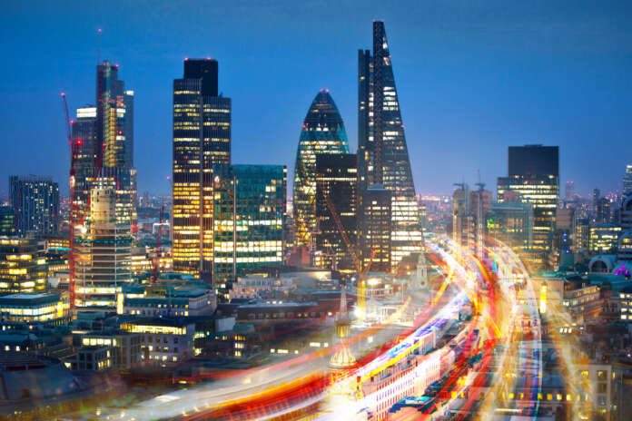 City of London view at sunset and busy road with transport blurred lights. Success, transformation and innovation idea.