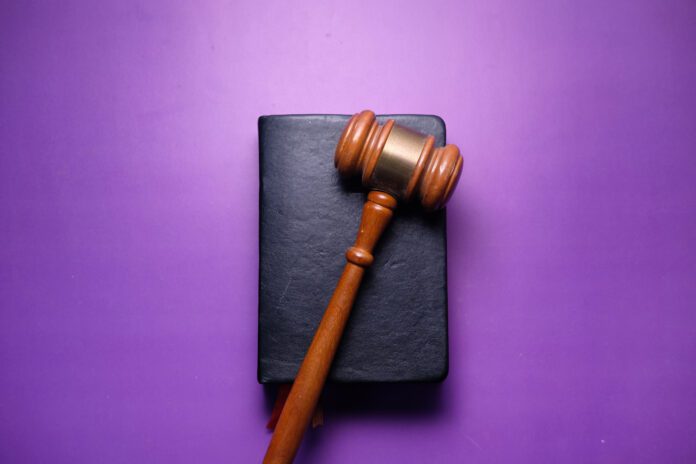 Close up of gavel and book on purple background