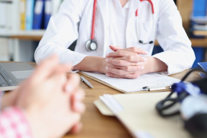 Hands of doctor and patient on work table in medical office