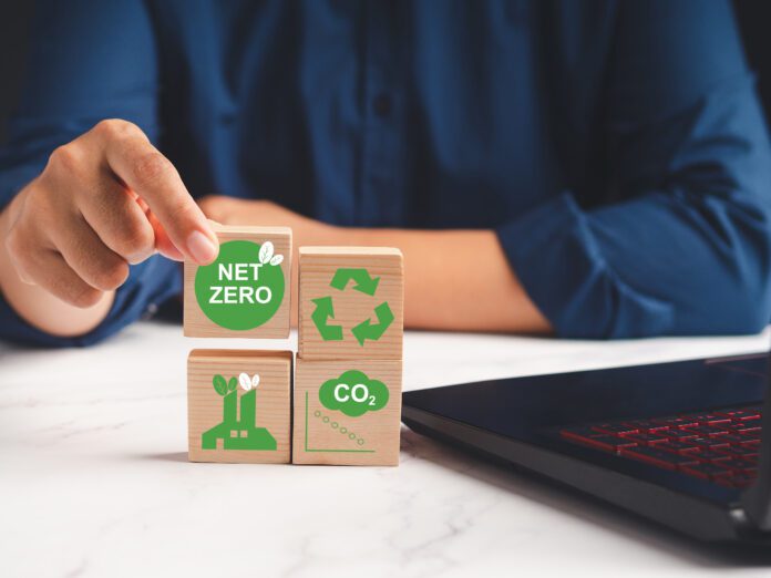 Hand holding a wooden cube with green icons over a marble table