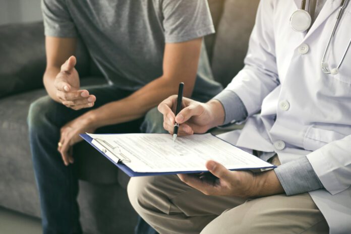 Doctor is recording the patient's information while the patient is explaining.