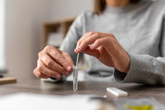 woman making self testing coronavirus test at home